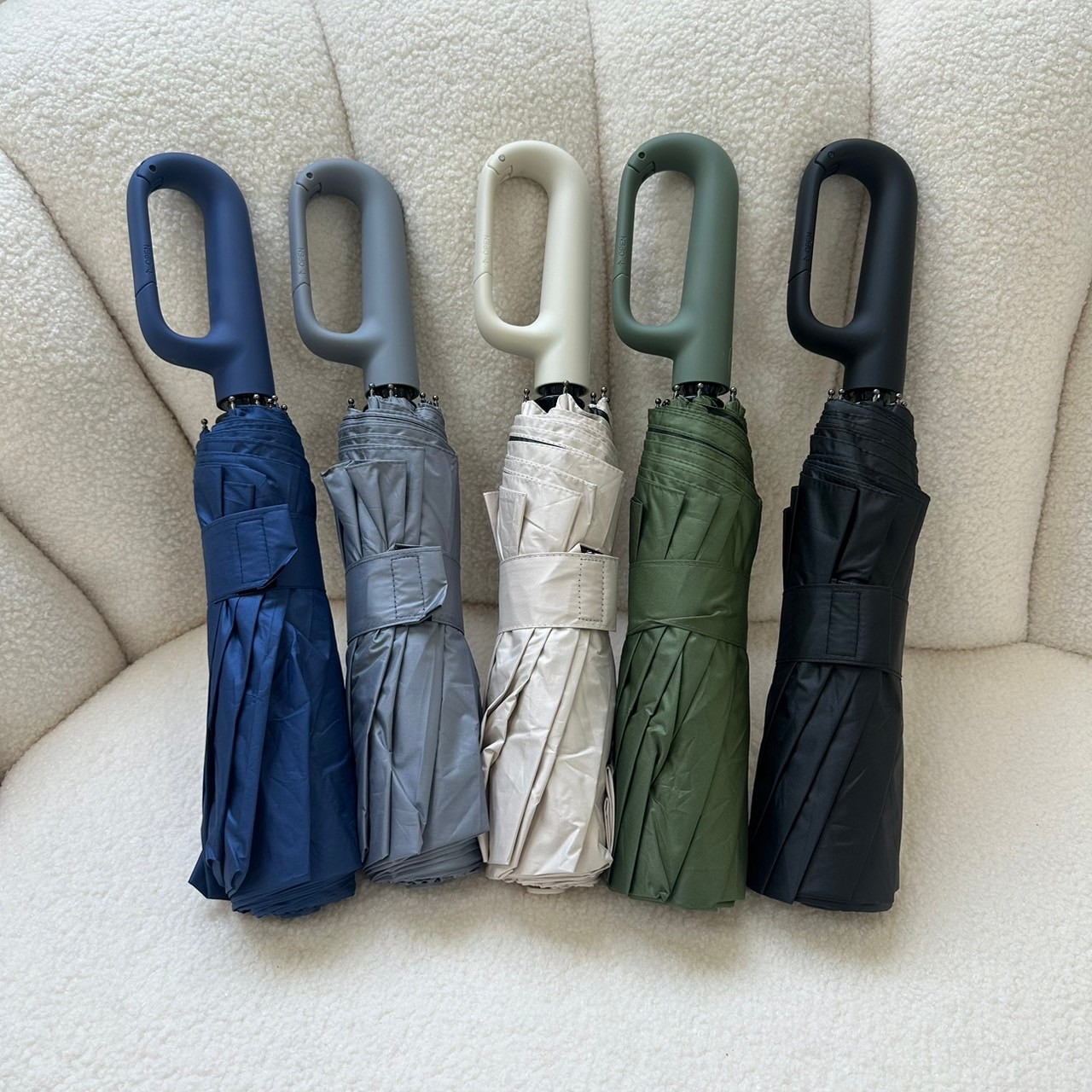 Ring buckle folding umbrellas in multiple neutral color options